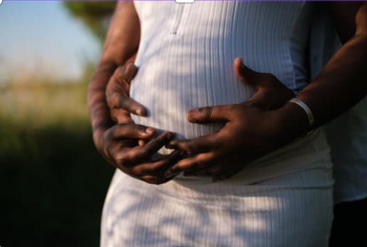 A couple embracing a pregnant belly