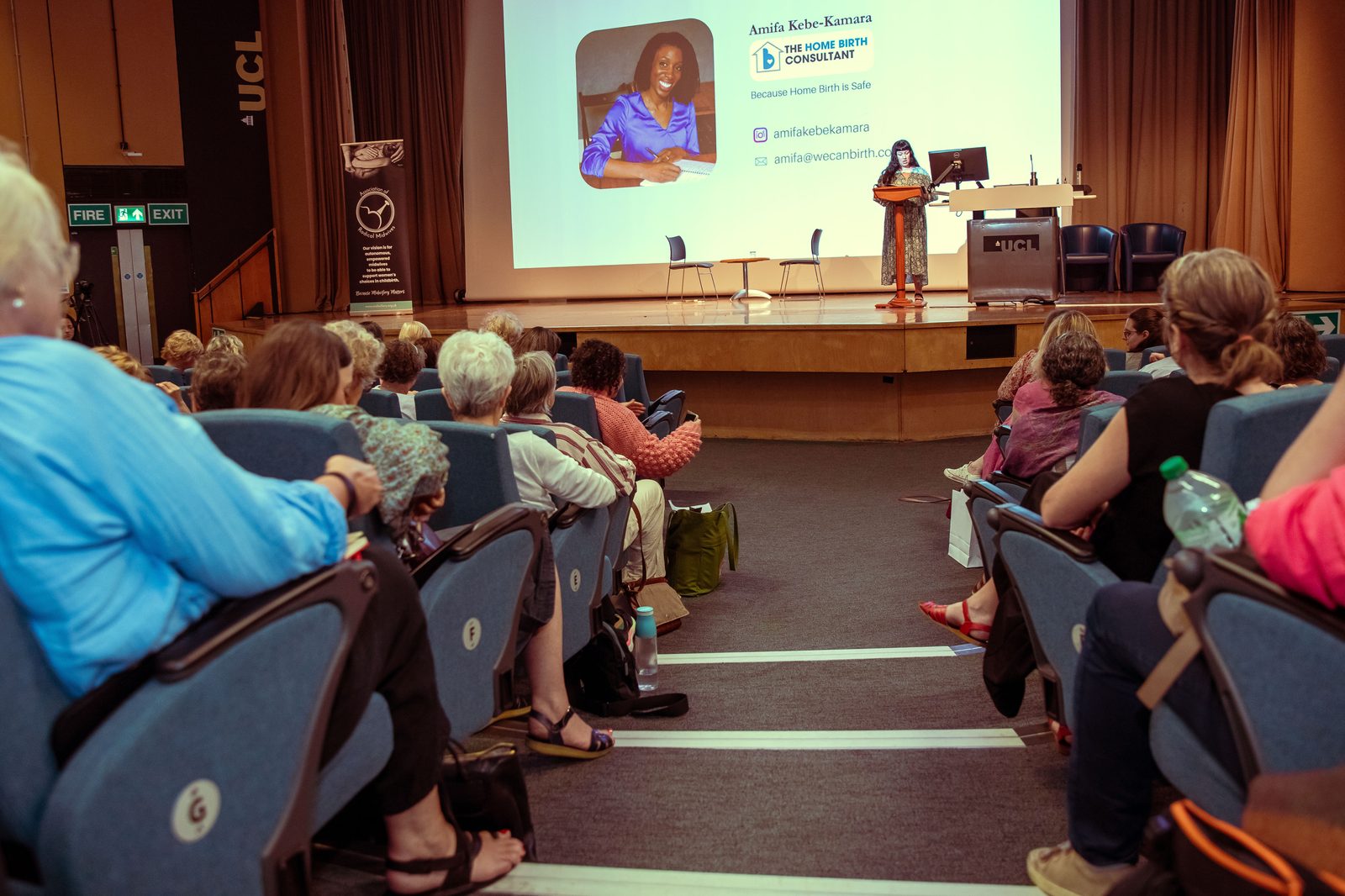Amifa Kebe-Kamara speaking at a conference podium